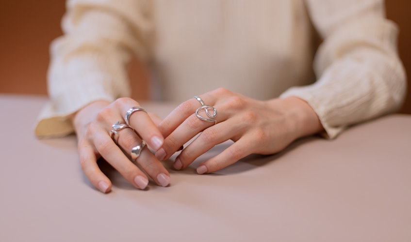 mujer llevando diferentes tipos de plata en sus anillos